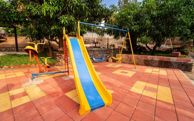 Children's play area with a slide under the trees at Redroof